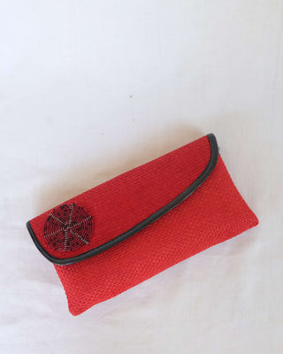 handcrafted red woven clutch bag with black beaded tribal design and flap closure