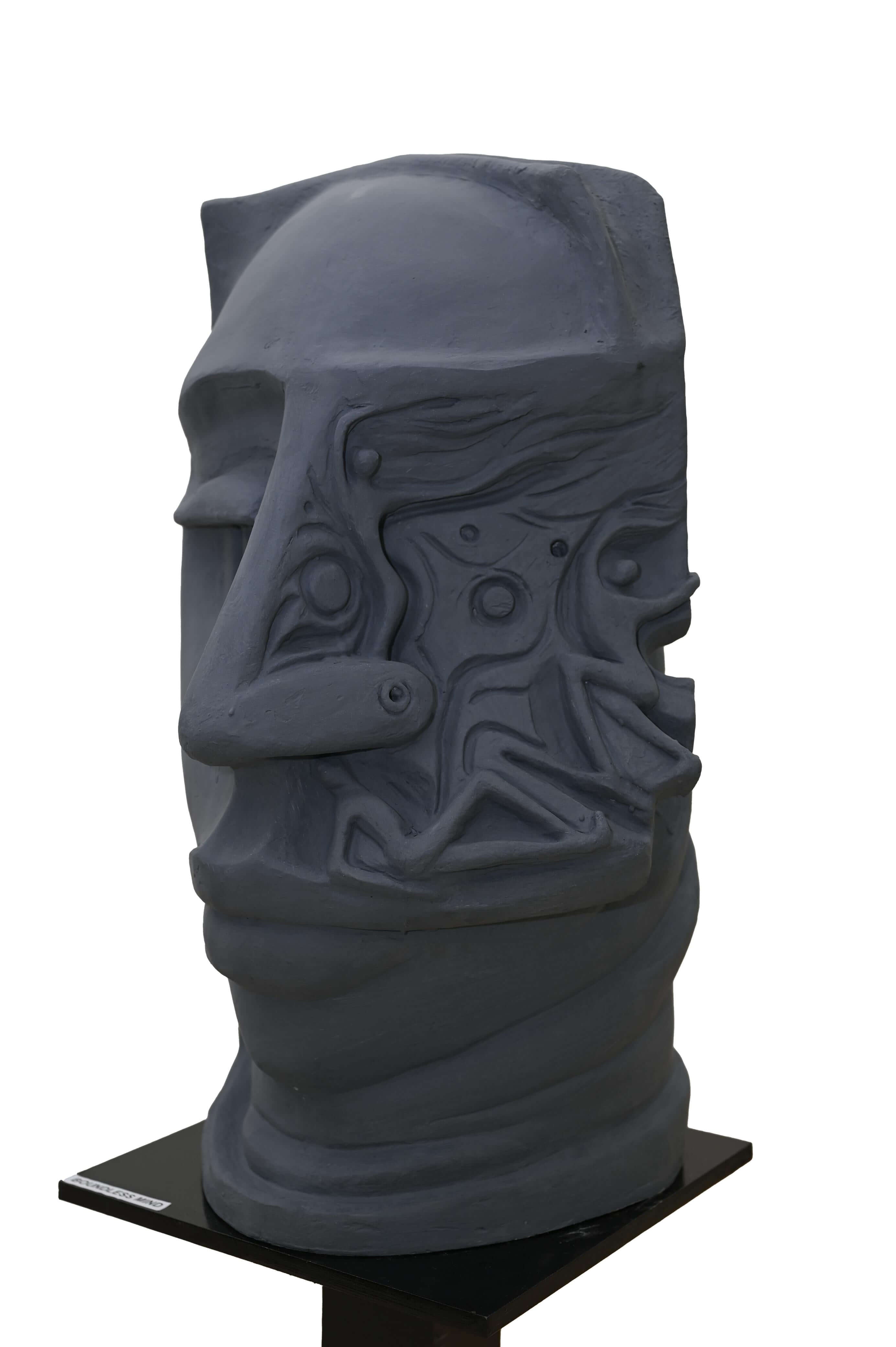 Abstract face sculpture in dark stone finish with surreal carved patterns, modern contemporary art for home and gallery décor.