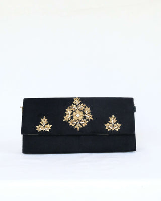 Black velvet clutch with gold floral embroidery on white background